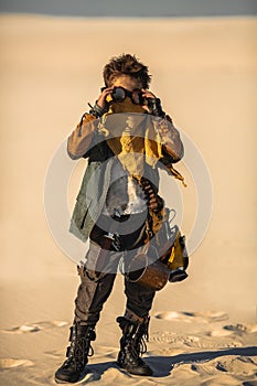 Post apocalyptic boy outdoors in desert.