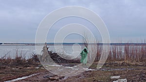 Post-apocalyptic concept - a man in a gas mask wearing protective suit on cloudy landscape