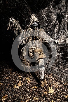 Post apocalyptic creature in gas mask armed gun