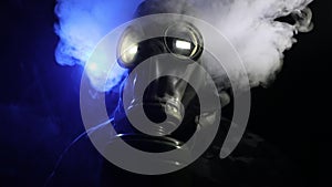 Post-apocalyptic survivor in gas mask on a dark background. Dramatic portrait of a man wearing a gas mask.