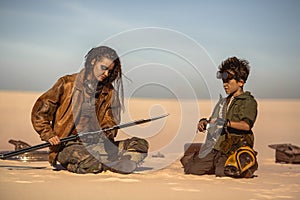 Post Apocalyptic Woman and Boy with Weapons Outdoors in the Wasteland