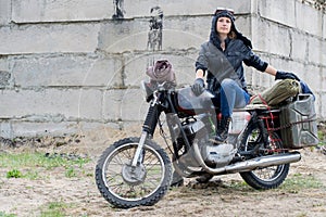 A post apocalyptic woman on motorcycle near the destroyed building