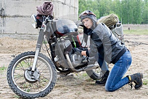 A post apocalyptic woman near motorcycle near the destroyed building