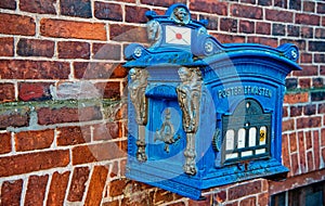 Post box blue color on red brick wall background