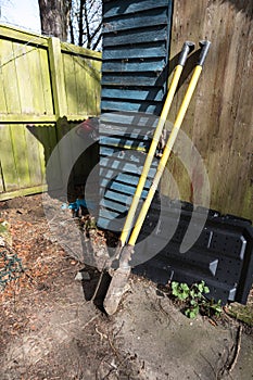 Post hole digger hand tool equipment for digging holes in the ground leaning against on old wooden shed