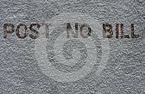 Post No Bill painted on a grey wall