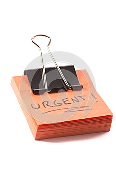 Post-it note with clip and message urgent on white background