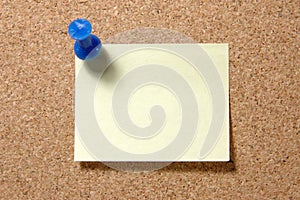 Post-it note with pushpin on corkboard