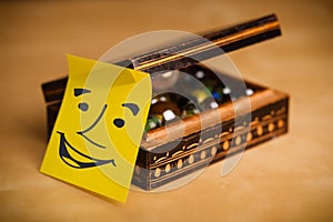 Post-it note with smiley face sticked on a box