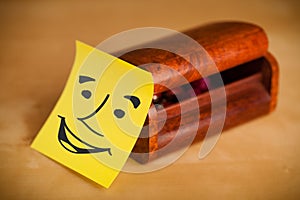 Post-it note with smiley face sticked on a box