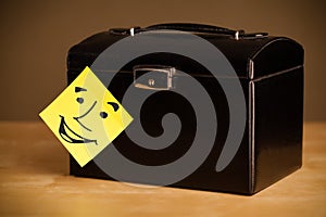 Post-it note with smiley face sticked on a box