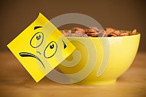 Post-it note with smiley face sticked on cereal bowl