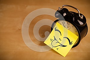 Post-it note with smiley face sticked on a clock