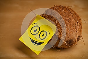 Post-it note with smiley face sticked on coconut