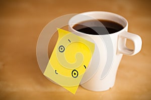 Post-it note with smiley face sticked on a cup