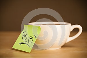 Post-it note with smiley face sticked on cup