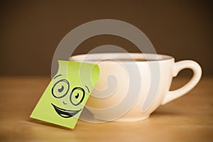 Post-it note with smiley face sticked on cup