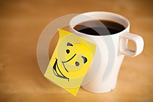 Post-it note with smiley face sticked on a cup