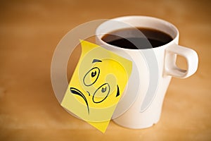 Post-it note with smiley face sticked on cup