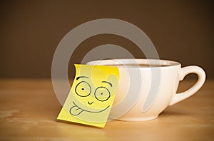 Post-it note with smiley face sticked on a cup