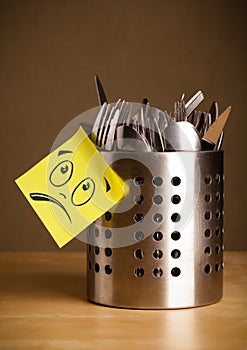 Post-it note with smiley face sticked on cutlery case