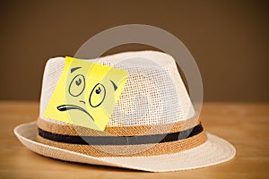 Post-it note with smiley face sticked on hat
