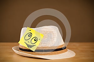 Post-it note with smiley face sticked on hat