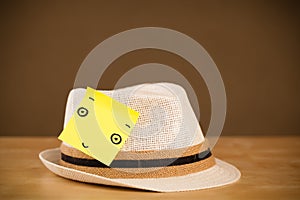 Post-it note with smiley face sticked on a hat