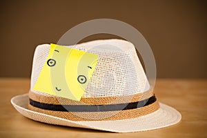 Post-it note with smiley face sticked on a hat