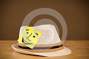 Post-it note with smiley face sticked on a hat