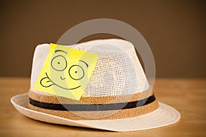 Post-it note with smiley face sticked on a hat