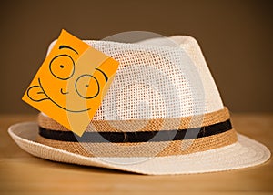 Post-it note with smiley face sticked on a hat