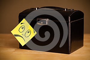 Post-it note with smiley face sticked on jewelry box