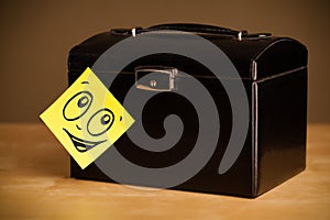 Post-it note with smiley face sticked on jewelry box