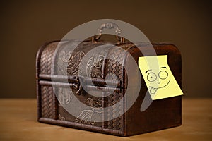 Post-it note with smiley face sticked on a jewelry box