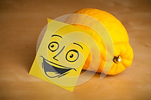 Post-it note with smiley face sticked on a lemon