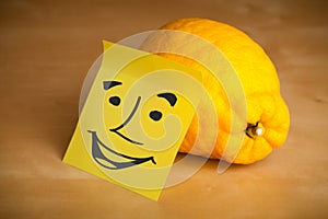 Post-it note with smiley face sticked on a lemon