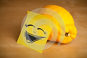 Post-it note with smiley face sticked on lemon