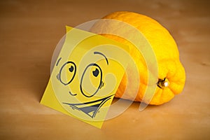 Post-it note with smiley face sticked on lemon