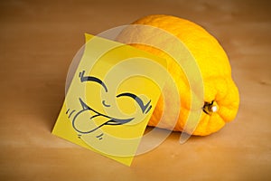 Post-it note with smiley face sticked on a lemon