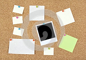 Post-it notes, papers and photo on a corkboard