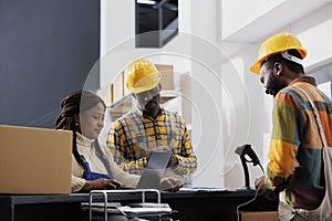 Post office employees making electronic invoice for customer parcel