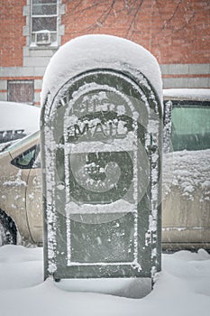 Post office mail box covered in snow on a cold snowy winter day in New York City