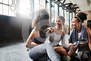 Those post workout chat sessions. a group of happy young women taking a break together at the gym.