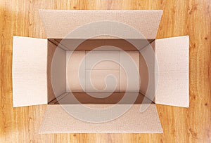 Postal cardboard box on a wooden floor.
