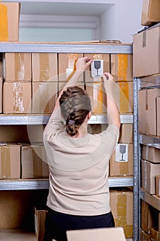 Postal worker sticking fragile or glass mark to parcel box at post office