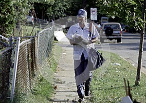 Postal worker walking delivering mail