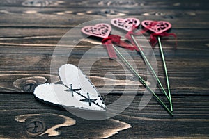 Postcard with wooden white heart and blurring decorative flowers on background