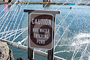 Posted sign read `Caution` and `Hot water entering pool` on a side of a pool