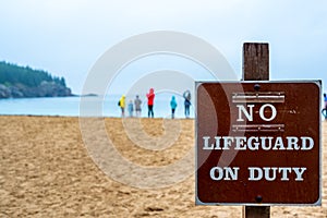 Posted sign at a sand beach stating No Lifeguard on Duty